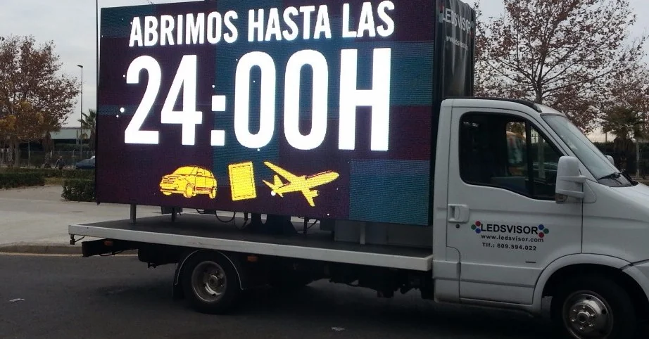 Camión de Ledsvisor con pantalla LED en el lateral mostrando un anuncio publicitario, aparcado en la vía pública